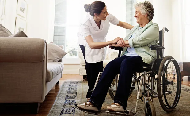 health care worker comfoting elderly patient in wheelchair